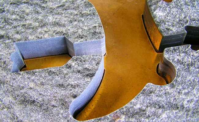 Inlay work for a well-known shoe retailer made of natural stones with an inset company logo in brass.