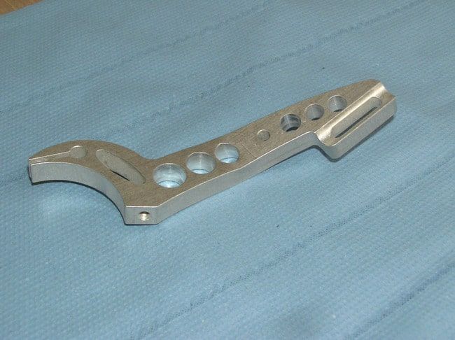 Wire rope tensioner, outer contour waterjet-cut, bores and half-round groove on CNC machining centre, bend produced on press brake.